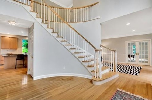 Grand curved staircase with white spindles
